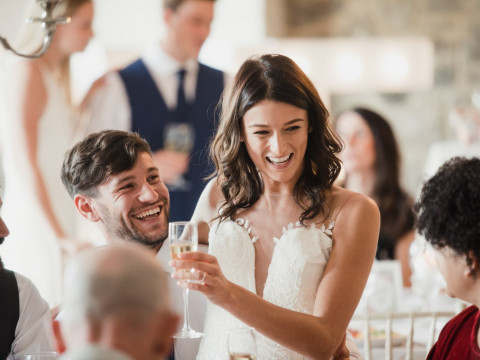 Bride laughing and toasting on her wedding day