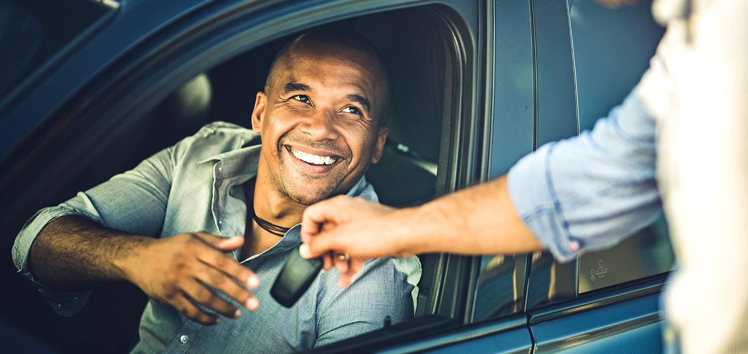 guy in a car being handed keys