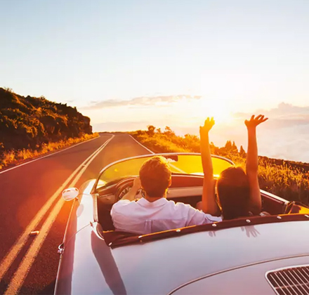 couple driving on a highway during sunset