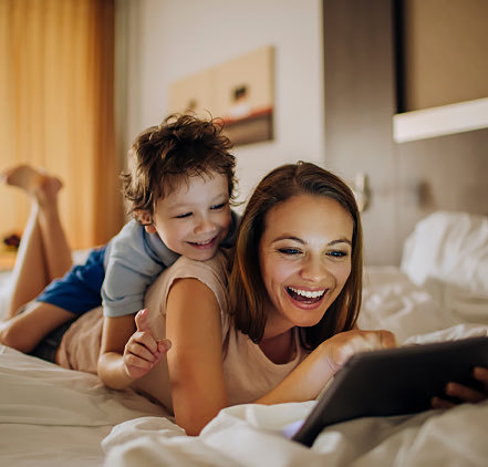 Woman with young son looking at an ipad and smiling
