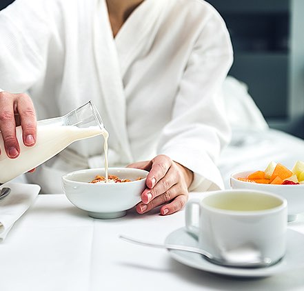 Guest enjoying room service breakfast in a robe