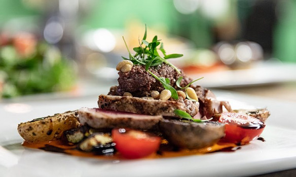 meat on top of potato and tomatoes