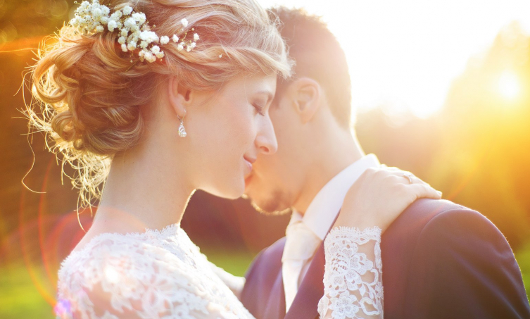 Close up of bride and groom hugging outdoors