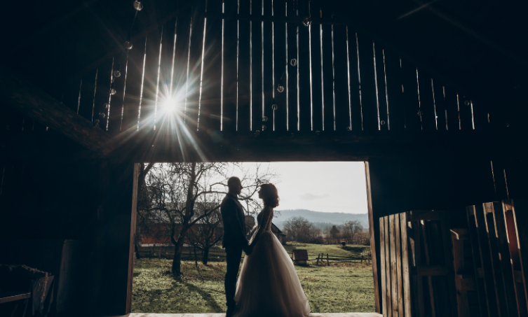 bride and groom holding hands in barn