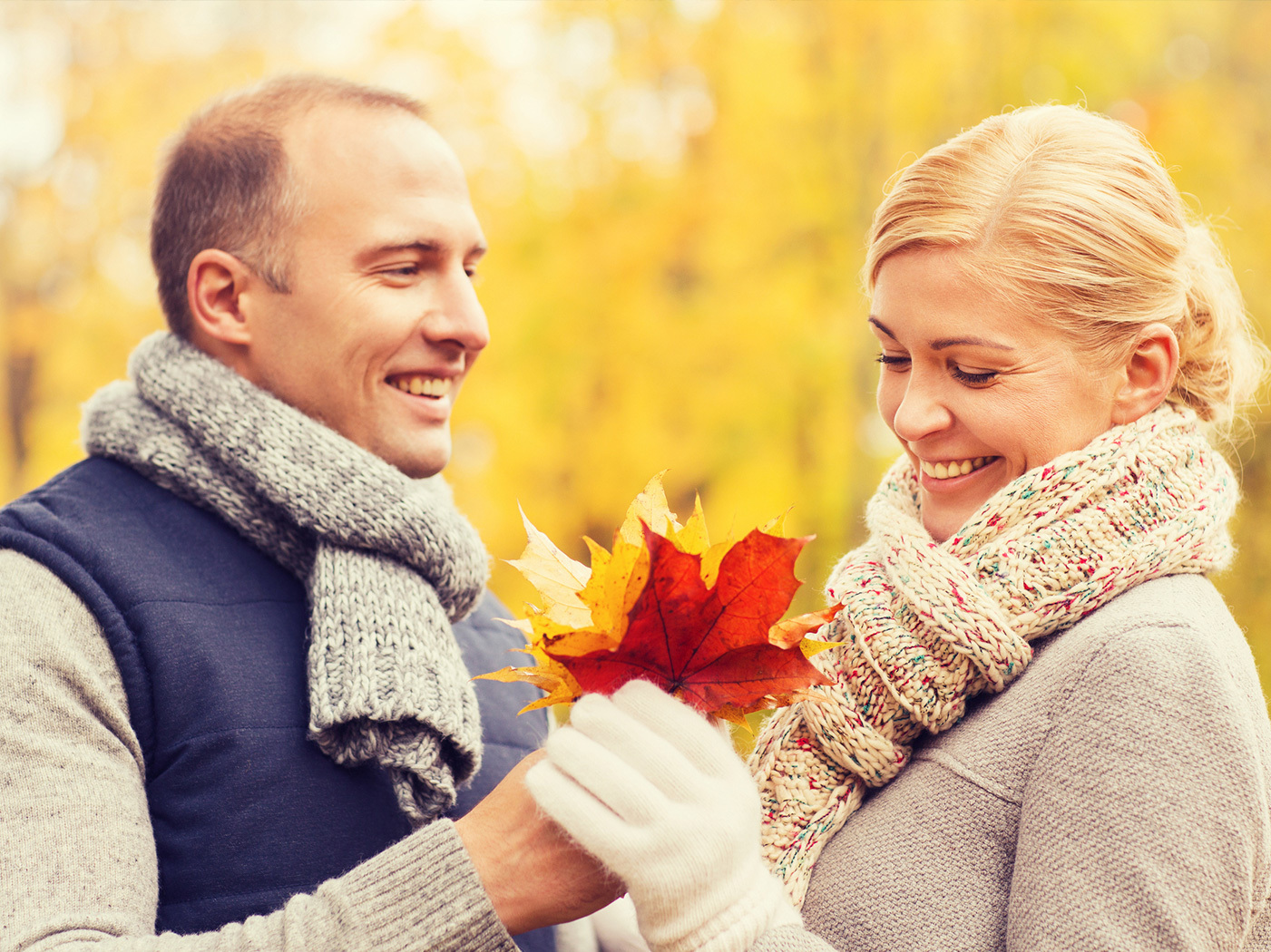 Man and woman holding fall leaves