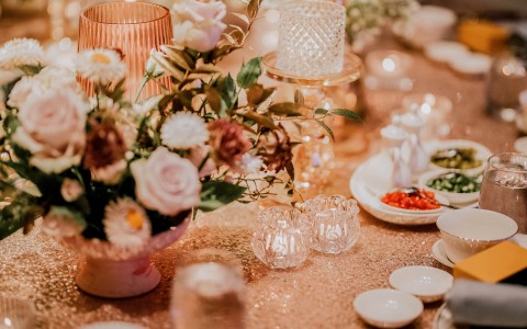close up of wedding reception plate settings with rose gold colors 