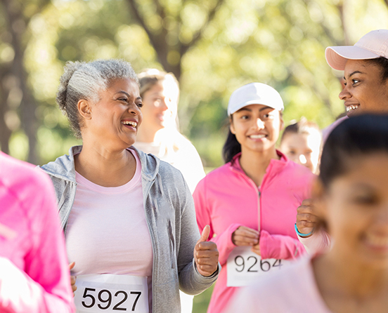 a group of friends in pink attire running for breast cancer awareness