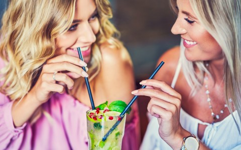 Women sharing a cocktail