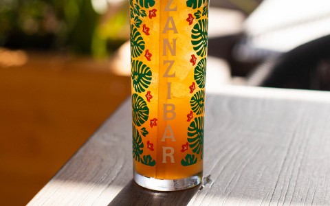 orange cocktail in tall skinny glass
