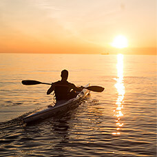 man kayaking in sunset