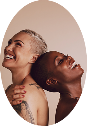 two naked woman with short hair smiling looking to different directions 