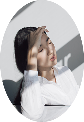  woman with her eyes closed covering herself from the light